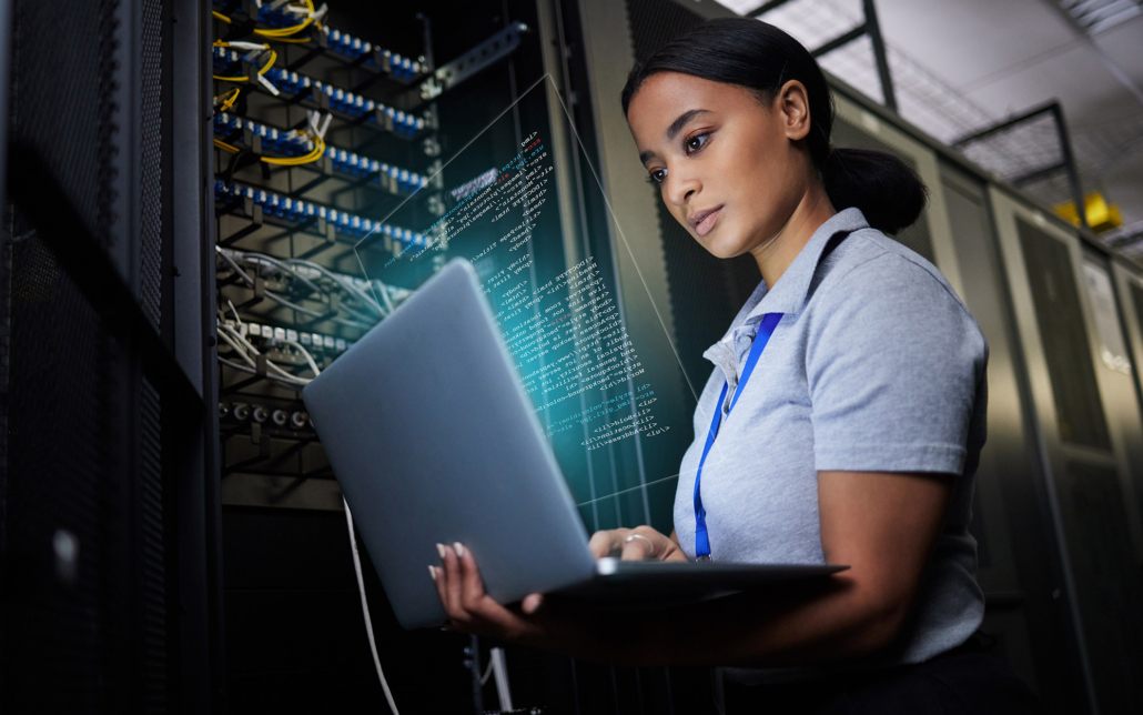 Professional in data center looking at laptop