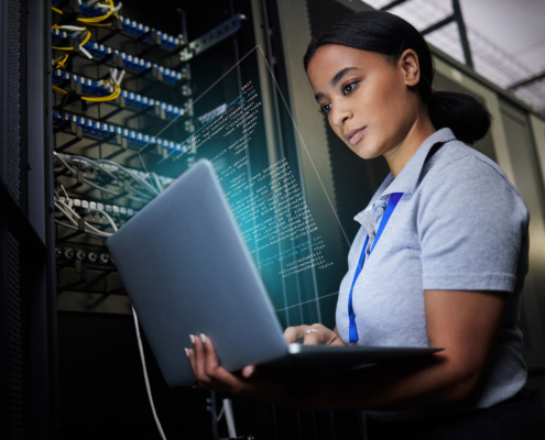 Professional in data center looking at laptop