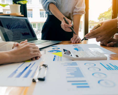 Collaborate at office desks to discuss paperwork